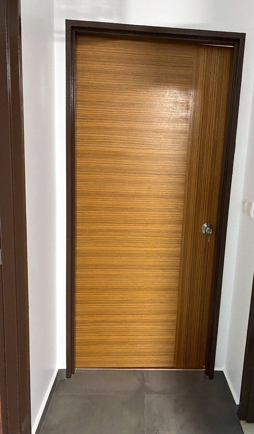 Installed wood-grain laminate bedroom door with round lock set, real Randy Reno job